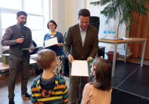 Dwoje dzieci odbiera dyplom od prezydenta Warszawy