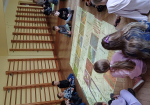 dzieci siedzą na podłodze interaktywnej