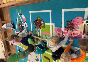 dzieci układają figury z materiału przyrodniczego