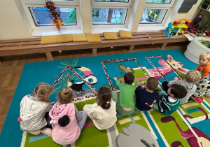 dzieci układają figury z materiału przyrodniczego