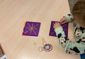 chłopiec układa wzór z gumek