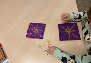 chłopiec układa wzór z gumek