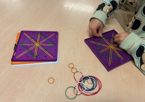 chłopiec układa wzór z gumek