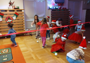 Dzieci przechodzą pod czerwoną wstążką