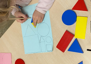 Dziecko odrysowuje figury geometryczne