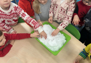 dzieci dotykają śniegu