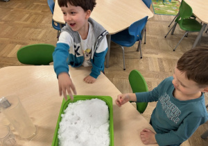 dzieci dotykają śniegu