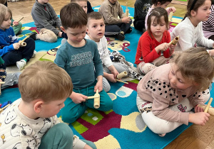 Grupa dzieci na dywanie z instrumentami