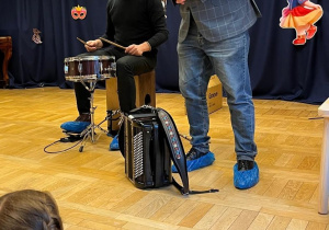 Prowadzący z instrumentami na scenie