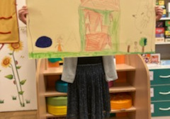 dziecko stoi ze swoim rysunkiem