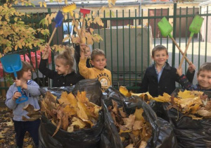 dzieci sprzątają liście