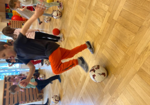 dzieci stawiają stopy na piłkach